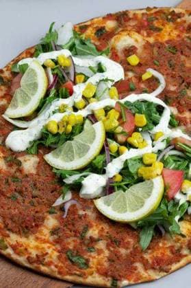 RECORD DATE NOT STATED A closeup of a lahmacun topped with lemons slices, herbs, corn kernels and tomatoes *** einer closeupe des einer lahmacun topped mit Zitronen slices, herbs, Mais kernels und Tomaten 3324956