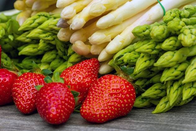 Grüne Spargel, weiße Spargel und frische Erdbeeren dekoriert auf einem rustikalen Holztisch *** Green asparagus, white asparagus and fresh strawberries decorated on a rustic wooden table Copyright: xx