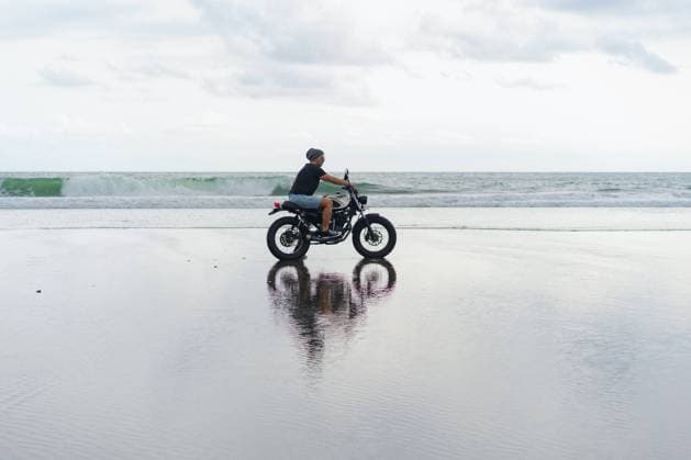 Young man riding a retro motorcycle on the beach. South Kuta, Bali, Indonesia CR_YUKI230502-1155371-01 ,model released, Symbolfoto