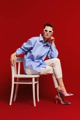 Creative Highlights Symbolbilder Erwachsene Frau mit Sonnenbrille, Hemd und Hose sitzt im Profil auf einem Stuhl und schaut geradeaus *** Adults Woman with Sunglasses, Shirt and Pants sits at Profile at a Chair and looks straight ahead Copyright: imageBROKER/AlekseixIsachenko ibxaii09194343.jpg ,model released, Symbolfoto ,property released