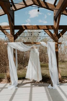 Wedding Dress hanging from the ceremony arbour in spring Winnipeg, Manitoba, Canada R_MFBW230503-1177876-01