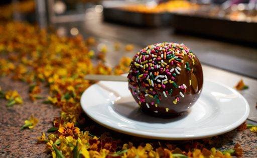 RECORD DATE NOT STATED A closeup of a delicious Candy Apple on a white plate *** einer closeupe des einer Köstlich Süßigkeit Apfel am einer weiß Teller 4510340