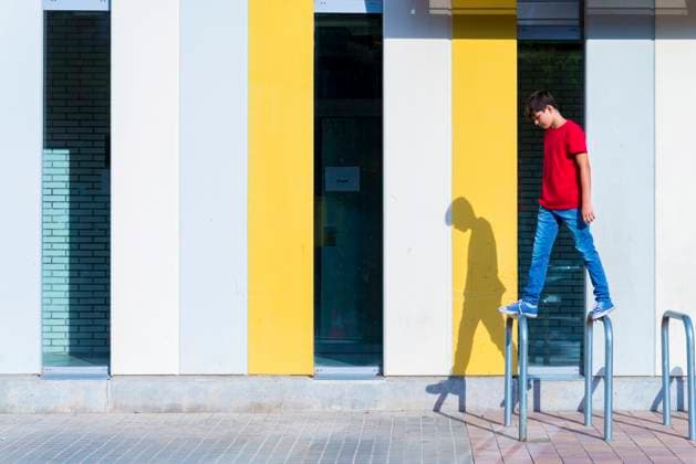 IMAGO Creative, Urban Lifestyle Portrait of a young teen sitting on urban cycle stands against a wall Granollers, Catalonia, Spain CR_RAFE230222-1128855-01 ,model released, Symbolfoto