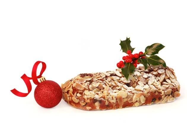 Stollen christmas cake with decorative holly leaf sprig and red berries with a sparkling red bauble, over white background. Copyright: xmarilynxbarbonex xDesignxPicsx , 30922201 Copyright: marilynxbarbonex xDesignxPics 30922201