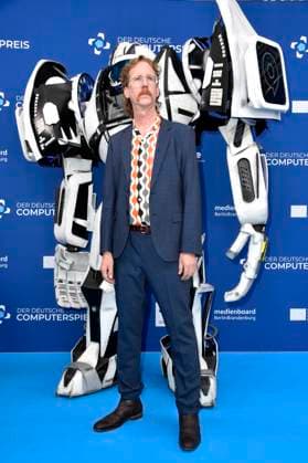 Uke Bosse mit Gamescom Bot bei der Verleihung des Deutschen Computerspielpreises 2023 im Spindler & Klatt. Berlin, 11.05.2023