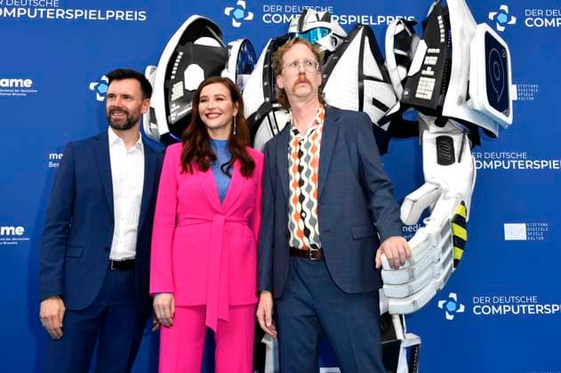 Felix Falk, Katrin Bauerfeind und Uke Bosse mit Gamescom Bot bei der Verleihung des Deutschen Computerspielpreises 2023 im Spindler & Klatt. Berlin, 11.05.2023
