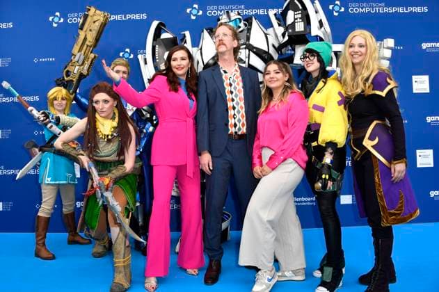 Katrin Bauerfeind, Uke Bosse und Olivia Osthushenrich aka Ollimeee mit Gamescom Bot und den Cosplayern Princess Link, Aloy, Soldier 76, Killjoy und Zelda bei der Verleihung des Deutschen Computerspielpreises 2023 im Spindler & Klatt. Berlin, 11.05.2023
