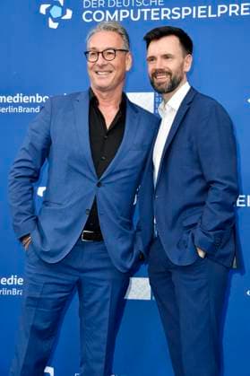 Helge Jürgens und Felix Falk mit Gamescom Bot bei der Verleihung des Deutschen Computerspielpreises 2023 im Spindler & Klatt. Berlin, 11.05.2023