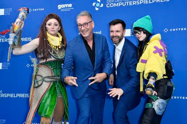 Helge Jürgens und Felix Falk mit den Cosplayern Aloy und Killjoy bei der Verleihung des Deutschen Computerspielpreises 2023 im Spindler & Klatt. Berlin, 11.05.2023