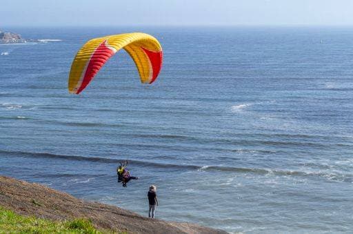 RECORD DATE NOT STATED A person observes two people paragliding over the Costa Verde in the city of Lima. *** einer person observes Zwei Personen Gleitschirmfliegen trueber der costä Verde ÊIn der Stadt des Lima 5651604