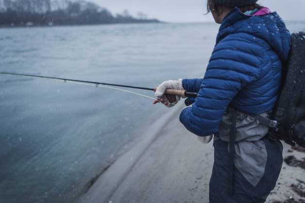 Woman angler casting fly rod in snow storm Scarborough, Maine, United States CR_BRDO230213C-1126636-01 ,model released, Symbolfoto