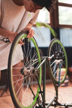 asian female queer bike mechanic works on vintage wheel at home CR_PIDODS230510-1039050-01 ,model released, Symbolfoto
