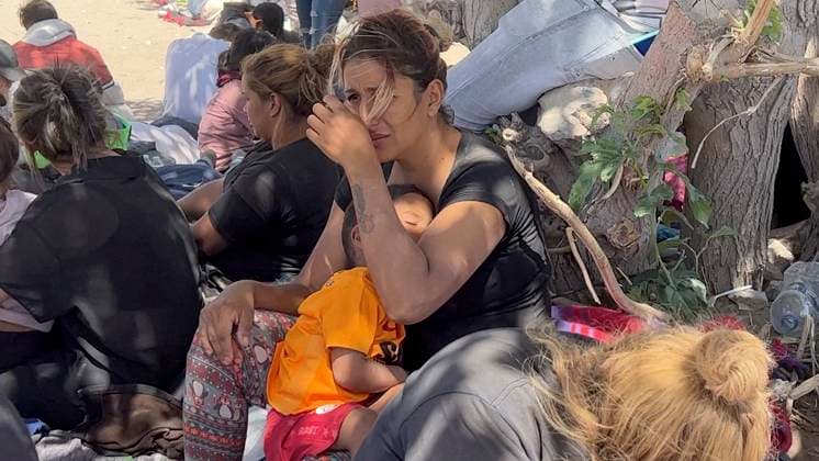 May 10, 2023, Juarez-El Paso Border, Texas, USA: Migrants wait to be processed at gate 40 of the border wall after having crossed the Rio Grande from Ciudad Juarez in hopes of turning themselves in with the intention of seeking asylum. Many migrants waited without shelter for lengthy periods of time. After six days outside, under extreme heat during the day, freezing temperatures at night and fierce sandstorms, women and small children crowded together under the shade of two trees. Juarez-El Paso Border USA - ZUMAing 20230510_new_s241_033 Copyright: xBelindaxSoncinix