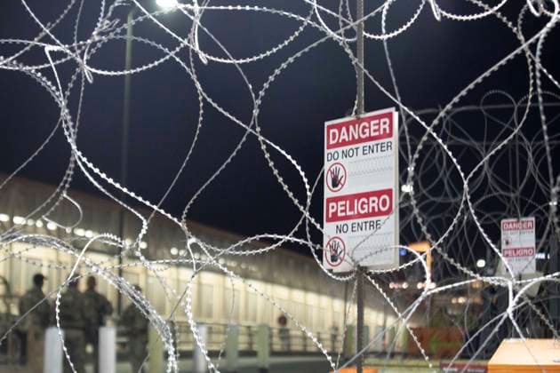 May 11, 2023, Juarez-El Paso Border, Texas, USA: Barbed wire is in the foreground as migrants wait to be processed at gate 40 of the border wall after having crossed the Rio Grande from Ciudad Juarez in hopes of turning themselves in with the intention of seeking asylum. Juarez-El Paso Border USA - ZUMAdnes 20230511_new_s241_025 Copyright: xBelindaxSoncinix