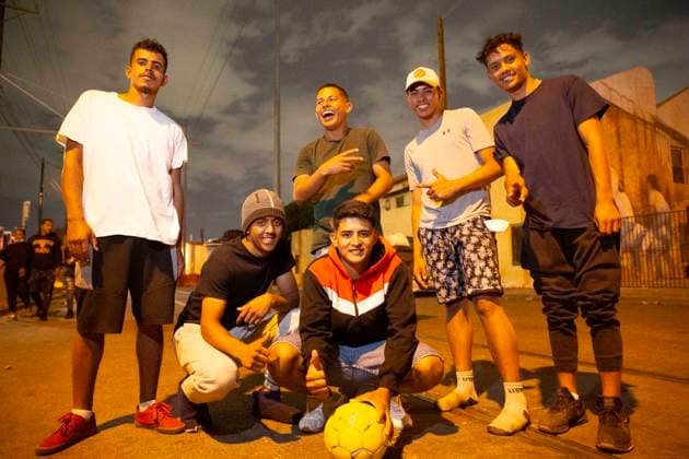 May 13, 2023, El Paso, Texas, USA: A group of mostly 19-year-olds from Venezuela and Columbia, who have been living on the sidewalk outside Sacred Heart Catholic Church since crossing the border from Juarez, Mexico this week, after Title 42 was lifted. When someone gave them a soccer ball earlier in the day, they played for six hours on the closed-off street. It almost makes us feel like we™re home, one of them said in Spanish. All of them had been working in their countries since they were young in order to support their families. They want to work again now that they are in the US, but are not permitted to work while awaiting their asylum hearings, which could take more than a year. Left to right: WILME, CARLOS, SHRISTIAN (standin - ZUMAs li 20230513_new_s241_040 Copyright: xBelindaxSoncinix