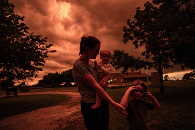 Bilder des Jahres 2023, News 05 Mai News Themen der Woche KW20 News Bilder des Tages USA, Sturm über Sanger in Texas färbt Himmel orange May 15, 2023, Sanger, Texas, United States: The Texas skies turn a deep orange color as a large storm cell moves across the north east, 5 15 23 Sanger, Texas. Reports of large hail and high winds have been experienced. Courtney Olson (left), looks outside with her children to see the changing colored sky that looks apocalyptic. Sanger United States - ZUMAr164 20230515_zap_r164_002 Copyright: xChrisxRusanowskyx