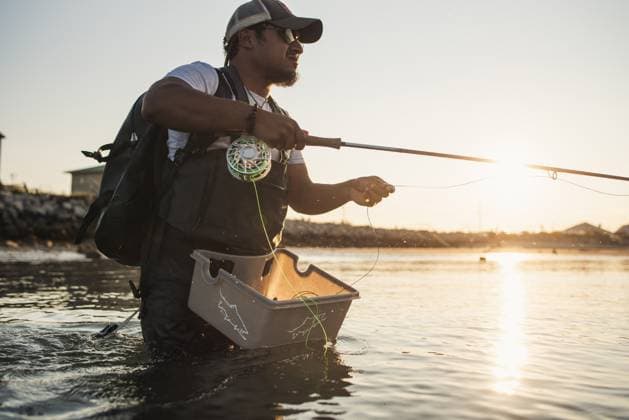 Hispanic man fly fishing in ocean off beach in afternoon Scarborough, Maine, United States CR_BRDO230210-1124482-01 ,model released, Symbolfoto