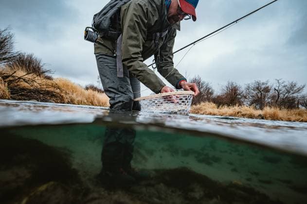 Underwater photo of fly fisherman unhooking fish in net Emigrant, Montana, United States CR_BRDO2302107A-1125086-01 ,model released, Symbolfoto