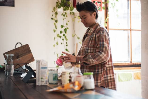 IMAGO Creative, Lifestyle, Tik Tok-Trend thatgirl queer asian woman measures baking ingredients in light home kitchen CR_PIDODS230510-1038785-01 ,model released, Symbolfoto ,property released