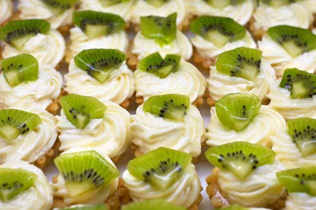Small cakes (petit four) with custard and kiwi on top. Shallow DOF. Sharp focus on second line. Copyright: xSergheixStarusx xDesignxPicsx , 31212239 Copyright: SergheixStarusx xDesignxPics 31212239