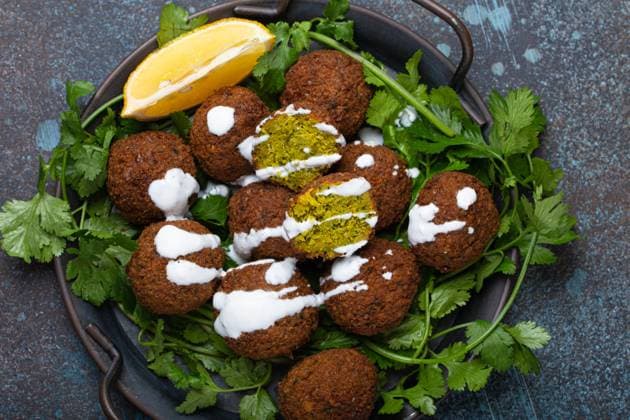 Plate of fried falafel balls served with fresh green cilantro and lemon, top view on rustic concrete background. Traditional vegan dish of Middle Eastern cuisine Plate of fried falafel balls served with fresh green cilantro and lemon top view on rustic concrete background. Traditional vegan dish of Middle Eastern cuisine Copyright: xZoonar.com OlenaxYeromenkox 19919954