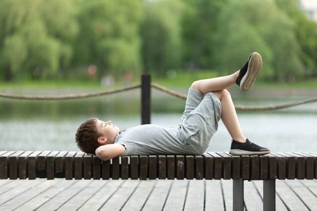 IMAGO Creative: Sommer, Sommertage im Stadtpark A school-age boy is lying on a bench in the park Moscow, Moscow, Russia CR_NAUG230213-1125971-01 ,model released, Symbolfoto