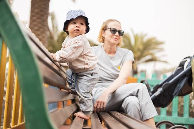 IMAGO Creative, Urban Lifestyle Young mother with her cute infant baby boy child on bench on urban children s playground on warm summer day. Young mother with her cute infant baby boy child on bench on urban children s playground on warm summer day ,model released, Symbolfoto Copyright: xZoonar.com MatejxKastelicx 20002348 ,model released, Symbolfoto ,property released