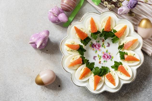 Stuffed eggs with cheese and salted salmon in the form of a carrot. Festive dinner, Easter brunch. View from above. Copy space. Stuffed eggs with cheese and salted salmon in the form of a carrot. Festive dinner, Easter brunch. View from above. Copy space. Copyright: xZoonar.com ELENAxHRAMOVAx 20013321