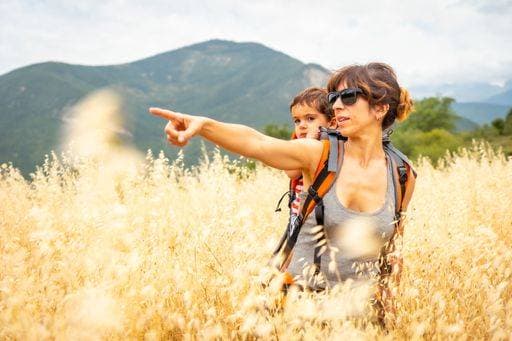 IMAGO Creative: Sommer, In den Bergen A Caucasian woman showing something with her finger carrying her son on the back in a wheat field *** einer kaukasisch Frau zeigend etwas mit her finger tragend her Sohn am der Rücken ÊIn einer Weizen Feld 7330887 ,model released, Symbolfoto RECORD DATE NOT STATED