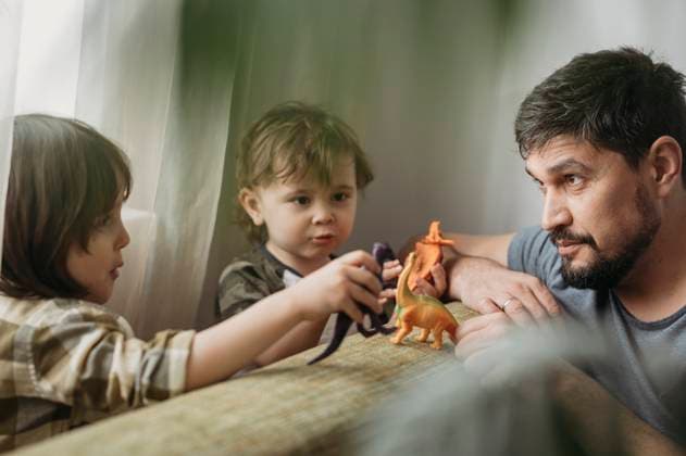 Sons playing with toy dinosaurs by father at home model released, Symbolfoto property released, ANAF01404