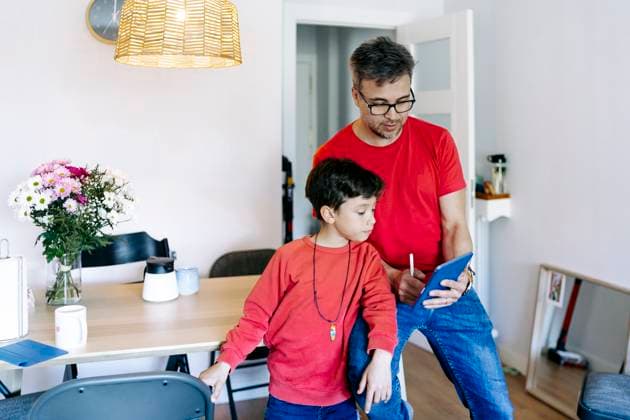 IMAGO Creative, Gesellschaft, Immer mehr Menschen haben Angst vor der Zukunft Son standing by father using tablet PC at home model released, Symbolfoto property released, JJF00907