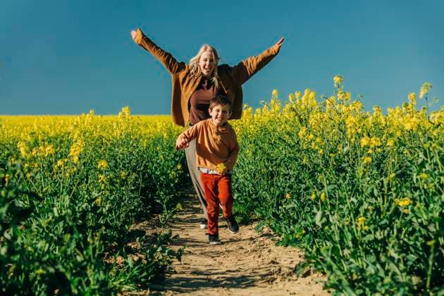 Playful mother and son running in rapeseed field model released, Symbolfoto, VSNF00775