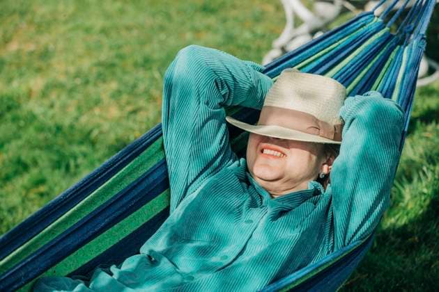 Senior woman with hands behind head relaxing on hammock at sunny day model released, Symbolfoto, VSNF00786