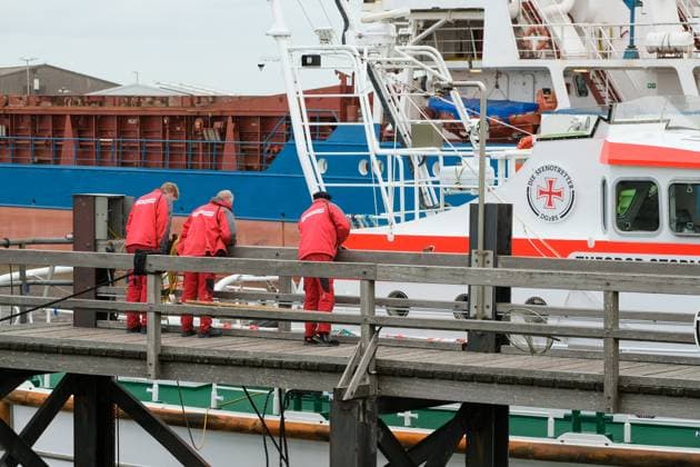 20230523 Nachdem das Schiff Rebecca Hammann hier im Hafen von Büsum den Seenotkreuzer Theodor Storm gerammt hat, verfolgen Seenotretter das Geschehen und inspizieren ihren Kreuzer. Büsum Schleswig-Holstein Germany *** 20230523 After the ship Rebecca Hammann rammed the sea rescue cruiser Theodor Storm here in the port of Büsum, sea rescuers follow the action and inspect their cruiser Büsum Schleswig Holstein Germany