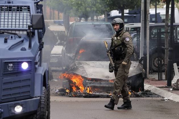 Bilder des Jahres 2023, News 05 Mai News Themen der Woche KW21 News Bilder des Tages Clashes between ethnic Serbs and Kosovo Police A Kosovo Police Special Unit officer walks near a burning car in Zvecan, Kosovo, on May 26, 2023. Clashes between ethnic Serbs and Kosovo Police began after the Serbs gathered in front of the municipality building trying to block the entrance to recently-elected officials. Stringer PIXSELL