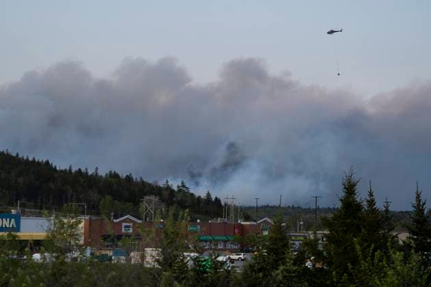May 28, 2023, Halifax, NS, Canada: A helicopter carrying water flies over heavy smoke from an out-of-control fire in a suburban community outside of Halifax that spread quickly, engulfing multiple homes and forcing the evacuation of local residents on Sunday May 28, 2023. Halifax Canada  - ZUMAc35_ 20230528_zaf_c35_051 Copyright: xDarrenxCalabresex