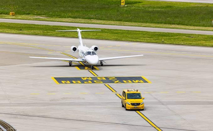 Ein Embraer Phenom 100 wird nach der Landung auf dem Flughafen Zürich von einem Bodenlotsen zum Standplatz geführt. (Zürich, Schweiz, 07.05.2023) Flugzeuge