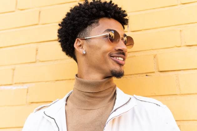 MR_ID13981_13396_VictorHugo.jpg Smiling young African American man in casual clothes and sunglasses dark curly hair looking away against a yellow brick wall on a city street, Model released DavidMunoz_ID13981_421629_020 Copyright: xDavidxMunozx MR