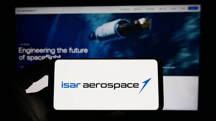 Person holding cellphone with logo of company Isar Aerospace Technologies GmbH on screen. Stuttgart, Germany - 04-02-2023: Person holding cellphone with logo of company Isar Aerospace Technologies GmbH on screen in front of business webpage. Focus on phone display. Copyright: xZoonar.com TimonxSchneiderx 20149441