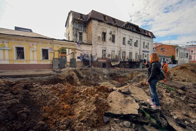 News Themen der Woche KW23 News Bilder des Tages KHARKIV, UKRAINE - JUNE 6, 2023 - A woman takes pictures of a crater left after the overnight shelling by Russian troops in central Kharkiv, northeastern Ukraine. As reported, rockets launched by Russians hit the car park near the airport and the road on Rymarska Street in the city centre. No casualties were reported. The rocket that landed on Rymarska Street cut off the water supply, smashed windows in the surrounding houses, and damaged five cars. Aftermath of Russian shelling in central Kharkiv  Copyright: xVyacheslavxMadiyevskyyx