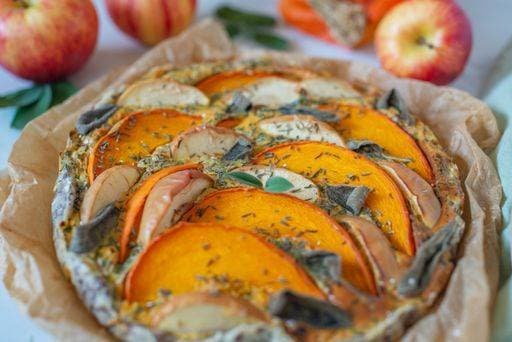 A closeup of pumpkin quiche on the table, apples around in the blurred background *** einer closeupe des Kürbis quiche am der table, Äpfel rund ÊIn der unscharf Hintergrund 9120724 RECORD DATE NOT STATED