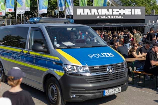 Ein Polizeiauto fährt an Fans vorbei, die Schlange stehen in der Hitze am Official Merchandise Stand beim Rammstein Konzert von Till Lindemann im Olympiapark in München Datum: 07.06.2023