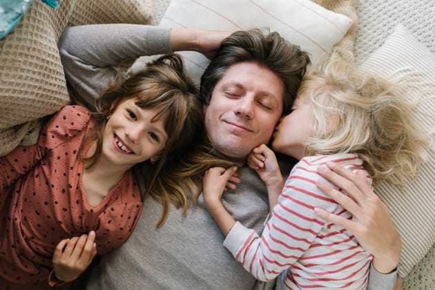 Happy father lying with daughters on pillows at home model released, Symbolfoto property released, TYF00109