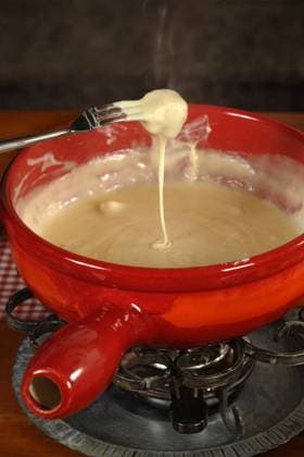 Bread being dipped into the melted cheese in the fondue bowl. Copyright: xRonxSumnersx xDesignxPicsx , 31561961 Copyright: IharxUlashchykx xDesignxPics 31561961 !ACHTUNG AUFNAHMEDATUM GESCHÄTZT! RECORD DATE NOT STATED
