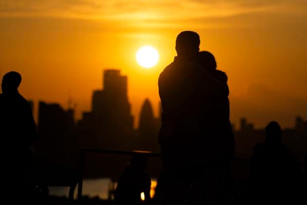 Two people hug as the watch the sunset over London on the Summer Solstice (21st June) seen from Greenwich Park, London. Greenwich London England Greenwich Park  Copyright: xBenjaminxGilbertx