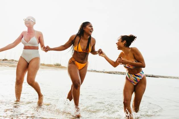 Playful friends in swimwear enjoying in sea model released, Symbolfoto, EBSF03352