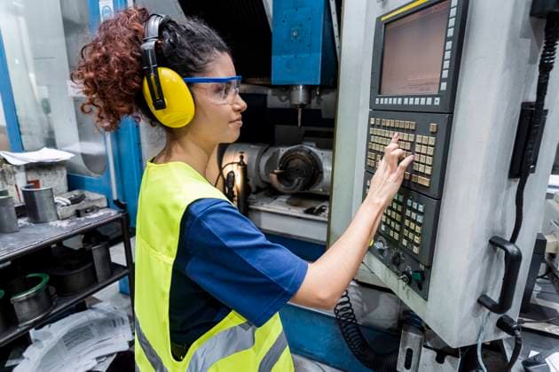 Engineer in protective workwear operating CNC machine in modern factory model released, Symbolfoto property released, AAZF00605