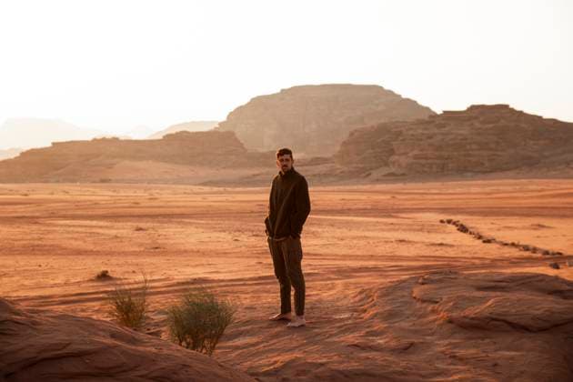 Young man with hands in pockets standing in desert at sunset model released, Symbolfoto, PCLF00562