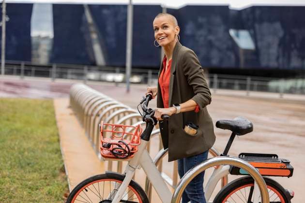 Woman holding bicycle at parking station model released, Symbolfoto, JCCMF10433