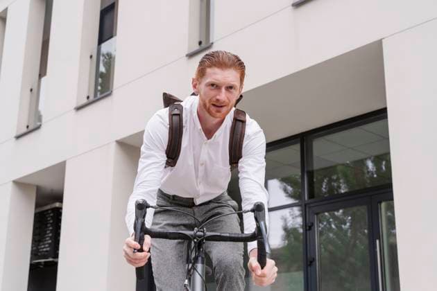 Businessman riding bicycle outside office model released, Symbolfoto property released, OSF01667